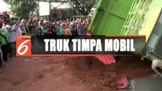 Warga Karawaci, Tangerang, dihebohkan dengan kecelakaan truk tanah yang oleng hingga menimpa sebuah taksi online.