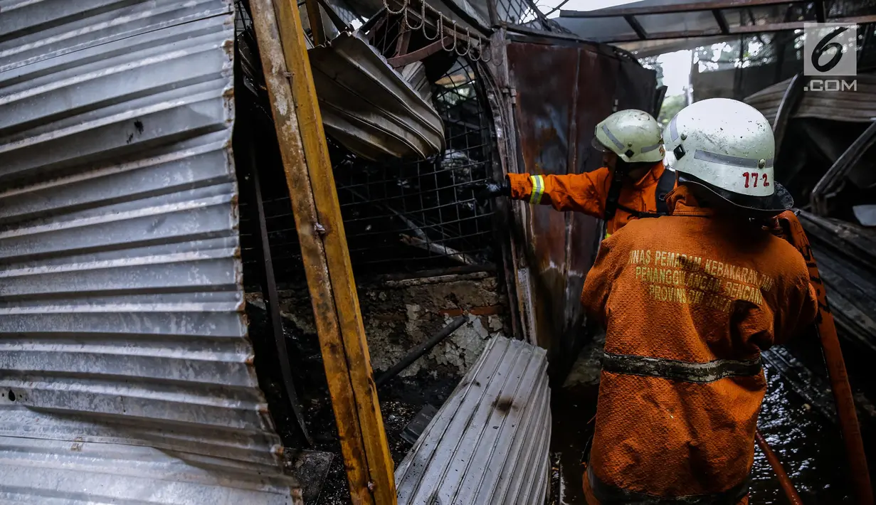 Petugas damkar berupaya memadamkan sisa bara api akibat kebakaran di Pasar Induk Kramat Jati Blok C1, Jakarta, Senin (12/6). Banyaknya bahan material yang mudah terbakar membuat api cepat membakar dan merambat ke kios lainnya. (Liputan6.com/Faizal Fanani)