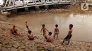 Sejumlah anak bermain di Bantaran sungai Kanal Banjir Barat, Tanah Abang, Jakarta, Sabtu (4/1/2020). Minimnya lahan bermain terpaksa membuat anak-anak harus bermain di bantaran Banjir Kanal Barat meskipun dapat membahayakan keselamatan dirinya. (Liputan6.com/Angga Yuniar)