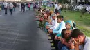 Warga duduk bersedih menunggu  iringan mobil jenazah Presiden Uzbekistan, Islam Karimov di Tashkent, Uzbekistan, (3/9).  Islam Karimov meninggal akibat penyakit stroke dan dugaan pendarahan di otak. (REUTERS/Muhammadsharif Mamatkulov)