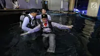 Artis peran Marsha Aruan masuk ke air untuk melakukan pengibaran bendera di dalam akuarium Seaworld Ancol, Jakarta, Jumat (17/8). Marsha terpilih sebagai salah satu pengibar bendera di dalam air memperingati HUT ke-73 RI. (Liputan6.com/Faizal Fanani)