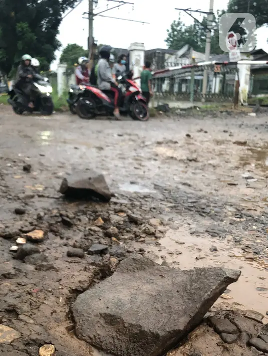 Kendaraan menghindari jalan yang rusak di Jalan Pertamina, Depok, Jawa Barat, Rabu (4/3/2020). Jalan yang telah rusak selama bertahun-tahun tersebut tidak juga diperbaiki sehingga mengganggu kenyamanan para pengguna jalan. (Liputan6.com/Immanuel Antonius)