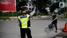 Petugas gabungan mengarahkan pengguna sepeda saat pengalihan jalur pesepeda di kawasan Sudirman-Thamrin, Jakarta, Minggu (5/9/2021). Pemberlakuan jalur ganjil genap pada masa PPKM membuat pengguna sepeda dilarang melintasi kawasan ganjil-genap pagi ini. (Liputan6.com/Angga Yuniar)
