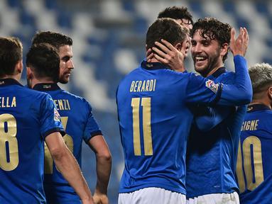 Striker Italia, Domenico Berardi (11), merayakan gol kedua Italia yang dicetaknya, bersama Manuel Locatelli dalam laga UEFA Nations League Grup A1 melawan Polandia di Stadion Mapei, Italia, Senin (16/11/2020) dini hari WIB. Italia menang 2-0 atas Polandia. (AFP/Miguel Medina)