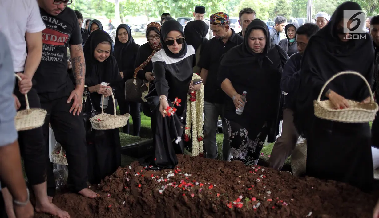 Aktris Olla Ramlan menaburkan bunga saat proses pemakaman sang ayahanda, Muhammad Ramlan di TPU Tanah Kusir, Jakarta, Selasa (5/6). Ayahanda Olla Ramlan meninggal di usia 72 tahun akibat kanker dan liver yang dideritanya. (Liputan6.com/Faizal Fanani)