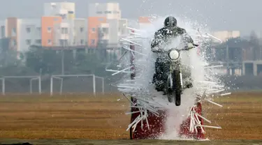 Seorang anggota tentara India dari tim sepeda motor 'Tornado' menabrak lampu selama latihan gabungan di akademi pelatihan perwira di Chennai (9/3). (AFP Photo/Arun Sankar)