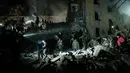 <p>Tim penyelamat memindahkan puing-puing untuk mencari korban selamat di gedung apartemen yang hancur terkena roket pada malam hari di pusat kota Kramatorsk, Ukraina timur, pada Rabu (1/2/2023). Sedikitnya 3 orang tewas dan 21 luka-luka dalam serangan itu. (Yasuyoshi CHIBA / AFP)</p>
