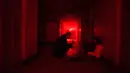 Pengunjung mendengarkan instruksi saat berada di dalam rumah hantu Quinta Nova da Assuncao di Belas, Portugal (13/5). Rumah hantu ini berisi 25 kamar dipenuhi penampakan bayangan dan suara dari pintu yang menutup secara acak. (REUTERS/Rafael Marchante)