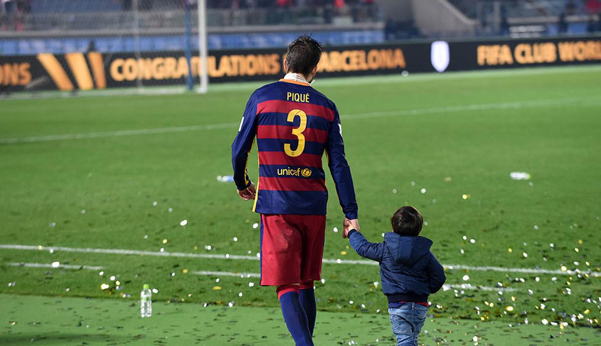 Bek Barcelona, Gerard Pique, turut mengajak putranya merayakan keberhasilan membawa Barca menjadi tim terbaik di dunia. (AFP/Toshifumi Kitamura)