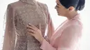 Pada acara resepsi kedua, Rizka mengenakan dress nuansa mauve lansiran brand lokal Khanaan.