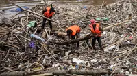Petugas kebersihan betopeng Spiderman membersihkan sampah yang menumpuk di Pintu Air Manggarai, Jakarta, Senin (12/11). Sebagian besar sampah seperti, batang pohon, bambu, setereofoam, plastik hingga kasur. (Liputan6.com/Fery Pradolo)