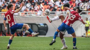 Pemain Atletico Madrid U-18 Adrian Gallego dan Ivan Hernandez bersaing dengan pemain Bali United U-18 pada laga perdana International Youth Championship (IYC) 2021 di Jakarta International Stadium (JIS), Rabu (13/4/2022). Atletico Madrid U-18 menang dengan skor 5-0. (Liputan6.com/Faizal Fanani)