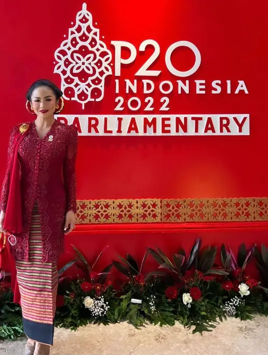 Untuk bawahannya, Krisdayanti tampak memilih kain tenun garis-garis yang sangat indah nuansa warna merah-emas. Dilengkapi dengan pointed heels dan tas berwarna emas. (Foto:Instagram/krisdayantilemos).