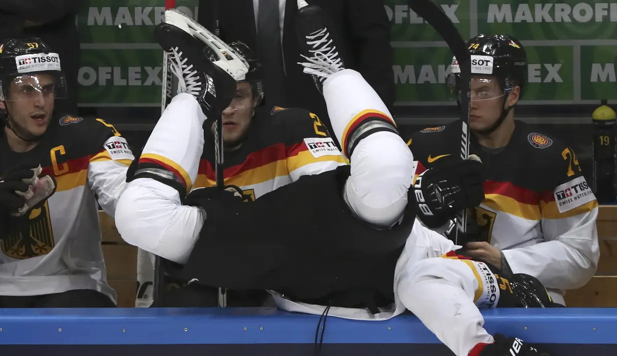 Pemain Ice Hockey Jerman, Korbinian Holzer terlempar keluar arena saat berebut bola dengan pemain Rusia pada kejuaraan IIHF World Championship 2016 di Moscow, Rusia, (19/5/2016). (REUTERS/Grigory Dukor) 