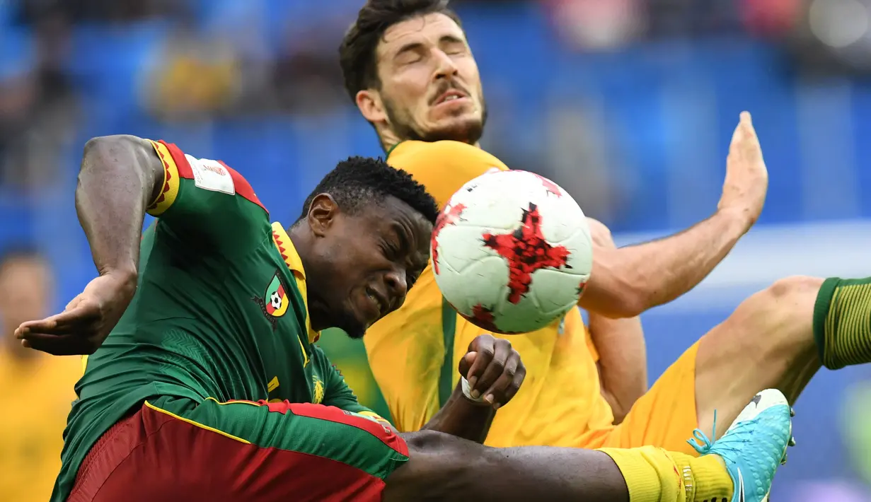 Ekspresi bek Kamerun, Collins Fai (kiri) saat berduel dengan pemain Australia, Milos Degenek pada laga grup B Piala Konfederasi 2017 di Saint Petersburg Stadium, (22/6/2017). (AFP/Kirill Kudryavtsev)