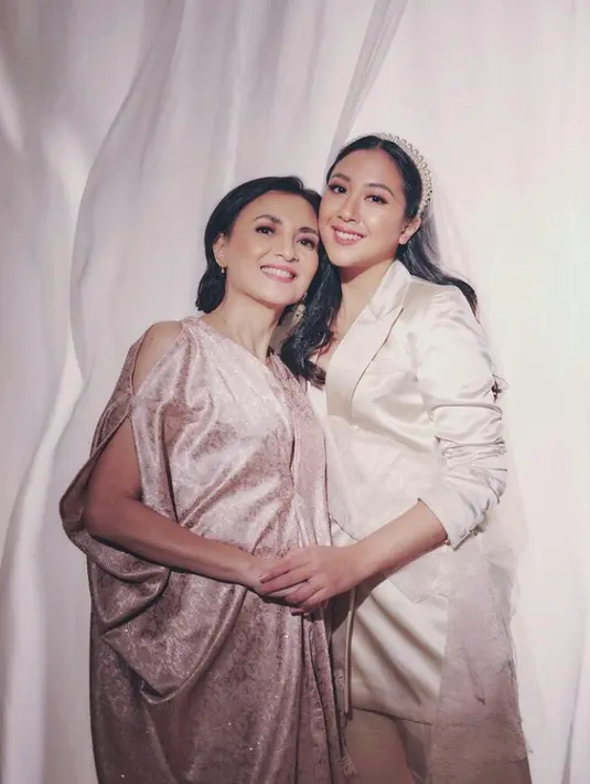 Penampilan musisi yang juga merupakan mantan artis cilik dengan sang ibu benar-benar manis. Pada momen pernikahannya, Sherina tampak serasi mengenakan outfit warna rose gold bersama sang ibu. (FOTO: Instagram.com/sherinasinna).
