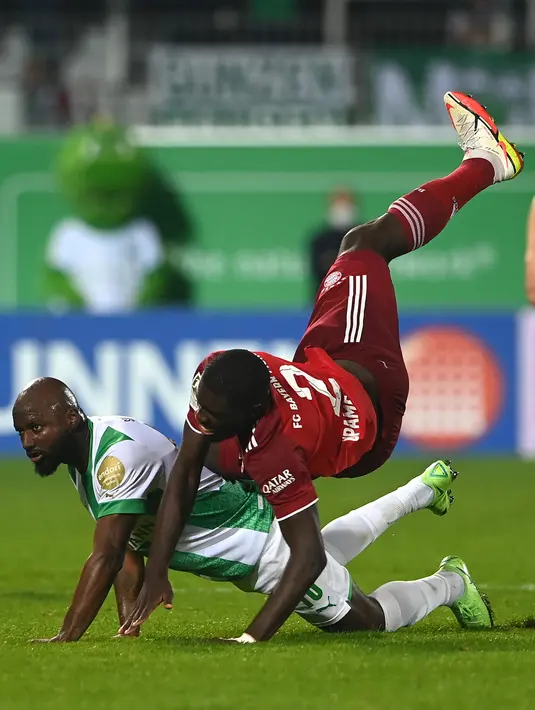 Bek Bayern Munchen Dayot Upamecano jatuh mengenai bek Greuther Fuerth Jetro Willems yang memperebutkan bola pada pekan keenam Liga Jerman 2021/2022 di Trolli Arena, Sabtu (25/9/2021) dini hari WIB. Die Roten –julukan Bayern Munchen – menang 3-1 atas tim promosi Greuther Furth. (Christof STACHE/AFP)