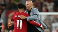 Pelatih Liverpool asal Belanda, Arne Slot, memeluk striker Mesir nomor punggung 11, Mohamed Salah, setelah pertandingan Premier League Inggris antara Liverpool dan Bournemouth di Anfield, Liverpool, Inggris barat laut, pada 15 Agustus 2025. Liverpool menang dengan skor 4-2. (Paul ELLIS/AFP)