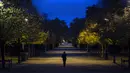 Seorang wanita berjalan di taman Tuileries yang kosong di pusat kota Paris (30/1/2020). Prancis memberlakukan kembali penguncian nasional selama sebulan yang bertujuan untuk memperlambat penyebaran virus, menutup semua bisnis yang tidak penting dan melarang orang masuk. (AP Photo/Lewis Joly)