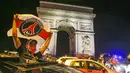 Seorang suporter mengibarkan bendera Paris Saint Germain (PSG) saat merayakan keberhasilan lolos ke final Liga Champions di Paris, Rabu (19/8/2020). Berkat kemenangan atas RB Leipzig, PSG untuk pertama kalinya berhasil lolos ke final Liga Champions. (AP/Michel Euler)