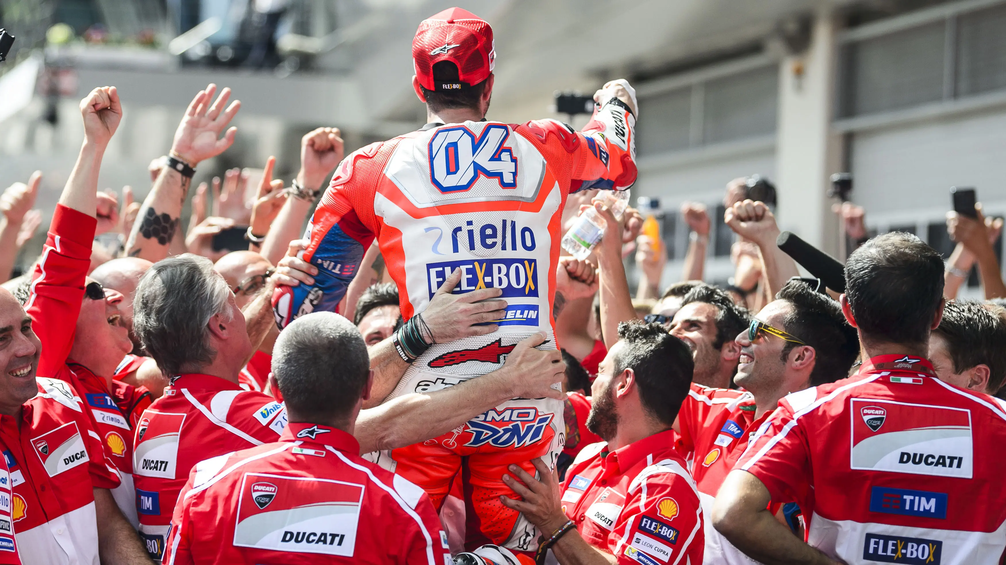 Andrea Dovizioso (tengah) merayakan kemenangan bersama tim usai balapan MotoGP Austria di Red Bull Ring, Spielberg, Austria (13/8/2017). Dovizioso menjadi juara stelah kalahkan Marquez pada lap terakhir. (AFP/Jure Makovec)
