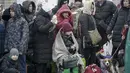 Orang-orang yang meninggalkan Ukraina menunggu bus untuk menuju stasiun kereta api di Przemysl, di perbatasan di Medyka, Polandia, Jumat (4/3/2022). PBB pada Kamis (3/3) melaporkan 1 juta orang telah meninggalkan Ukraina sejak invasi Rusia terhadap negara itu sepekan lalu. (AP Photo/Visar Kryeziu)