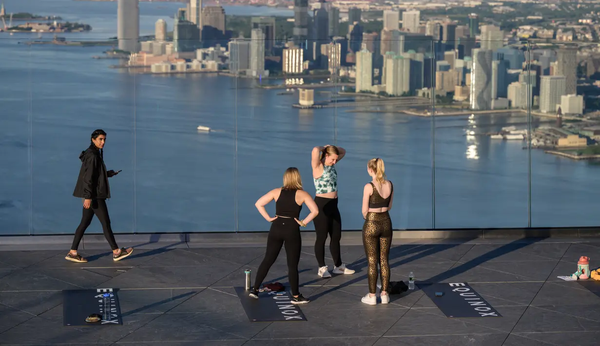 Praktisi yoga menghadiri kelas di Edge Observation Deck, Manhattan, New York, Amerika Serikat, Kamis (17/6/2021). Edge Observation Deck memiliki ketinggian 1.131 kaki (345 meter). (Ed JONES/AFP)