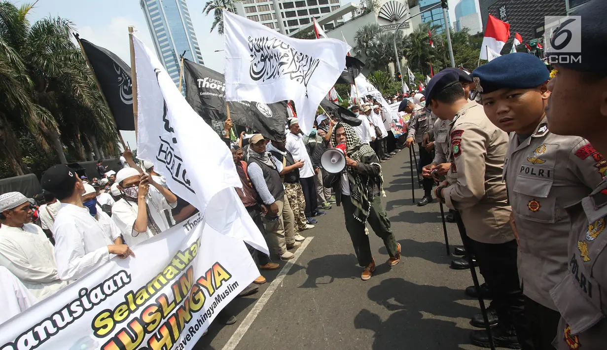 Personel kepolisan mengawal orasi Massa Aksi solidaritas Rohingya di kawasan Bundaran HI, Jakarta, Rabu (6/9). Selain itu, massa juga mendesak agar penghargaan nobel perdamaian kepada Aung San Suu Kyi dicabut. (Liputan6.com/Immanuel Antonius)