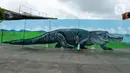Warga melintasi kreasi mural di sepanjang dinding bantaran Kali Opak, Jakarta Utara, Kamis (6/2/2020). Tembok bangunan saat ini tak hanya menjadi pembatas semata tapi dimanfaatkan untuk menyampaikan pesan-pesan dan harapan dalam bentuk goresan atau tulisan. (merdeka.com/Imam Buhori)