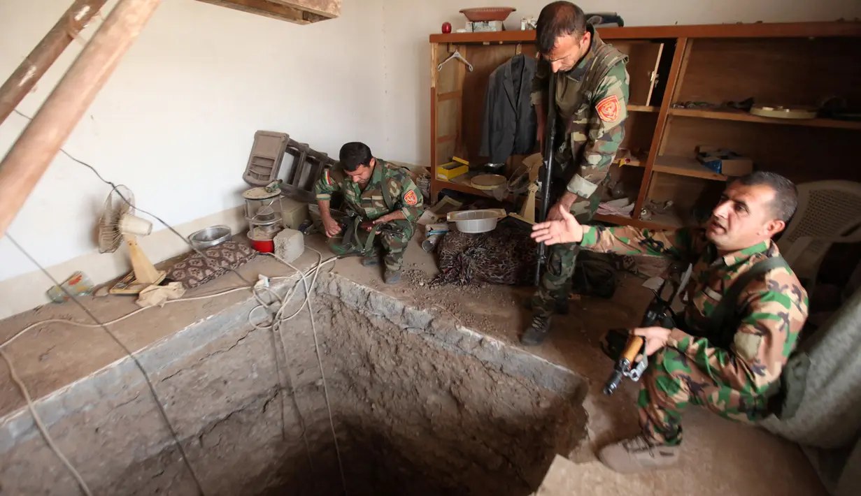 Tiga pasukan Peshmerga bersenjata memeriksa terowongan tempat persembunyian militan ISIS selama operasi penyerangan di Mosul, Irak (19/10). Operasi pengepungan oleh pasukan koalisi Irak untuk mengepung para militan ISIS. (REUTERS/Azad Lashkari)