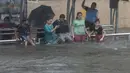 Anak-anak bermain di halte bus yang terendam banjir saat hujan lebat di Mumbai, India, Rabu (9/6/2021). Mumbai terendam banjir usai diguyur hujan lebat. (AP Photo/Rafiq Maqbool)