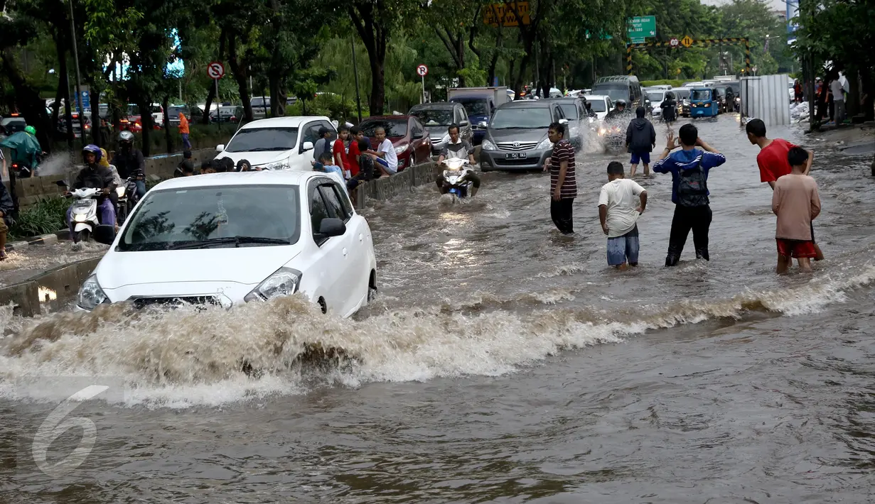Sejumlah kendaraan nekat menerobos banjir di depan Mall Gandaria City, Jakarta, Sabtu (27/8). Hujan deras di wilayah Jabodetabek membuat jalan tersebut banjir setinggi 30-50 cm. (Liputan6.com/Helmi Afandi)