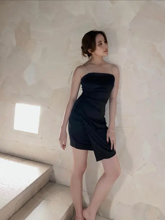 <p>Short dress hitam dengan detail serut dan berbahan satin slik akan membuatmu tampil memesona. (instagram/agatha_chelsea)</p>