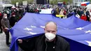 Pria memegang bendera Uni Eropa saat demonstrasi, Praha, Republik Ceko, Kamis (29/4/2021). Ribuan warga berunjuk rasa menentang Presiden Milos Zeman dan menuduhnya melakukan pengkhianatan atas sikap pro Rusia pada dugaan partisipasi mata-mata Rusia dalam ledakan di Ceko. (AP Photo/Petr David Josek)