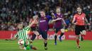 Gelandang Barcelona, Arthur Melo, berusaha melewati pemain Real Betis, Tello, pada laga La Liga 2019 di Stadion Benito Villamarin, Minggu (17/3). Barcelona menang 4-1 atas Real Betis. (AP/Miguel Morenatti)