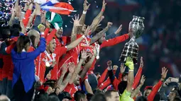 Para pemain Chili bersorak mengangkat trofi usai mengalahkan Argentina saat Final Copa America 2015 di Stadion Nasional, Santiago, Chili, (4/7/2015). Chili menang lewat adu penalti atas Argentina dengan skor 4-1. (REUTERS/Jorge Adorno)