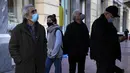 Dua pria lansia yang mengenakan masker membaca halaman depan surat kabar Yunani di Omonia square di Athena, Kamis (23/12/2021). Yunani membatalkan konser Natal dan acara lainnya sebagai bagian dari pembatasan baru yang mencakup mandat penggunaan masker di luar ruangan. (AP Photo/Thanassis Stavrakis