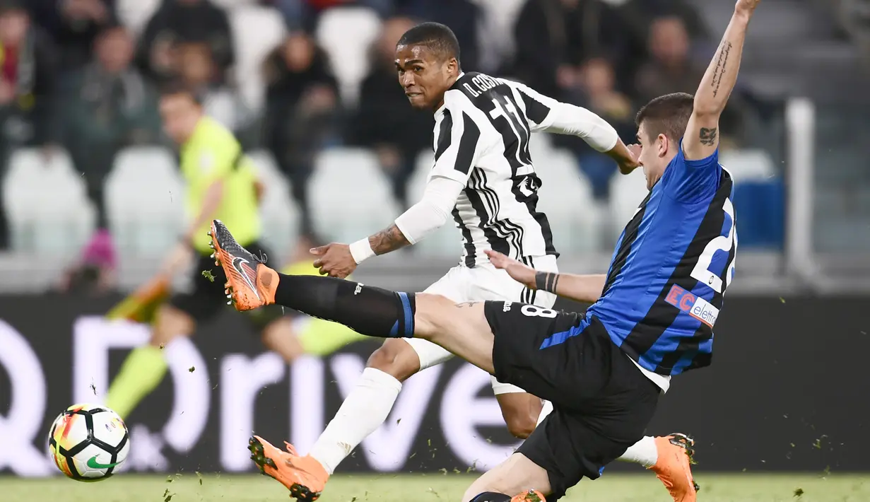 Aksi pemain Juventus, Douglas Costa (kiri) melepaskan tembakan melewati adangan pemain Atalanta pada lanjutan Serie A di Allianz Stadium, Turin, (14/3/2018). Juventus menang 2-0. (AFP/Marco Bertorello)