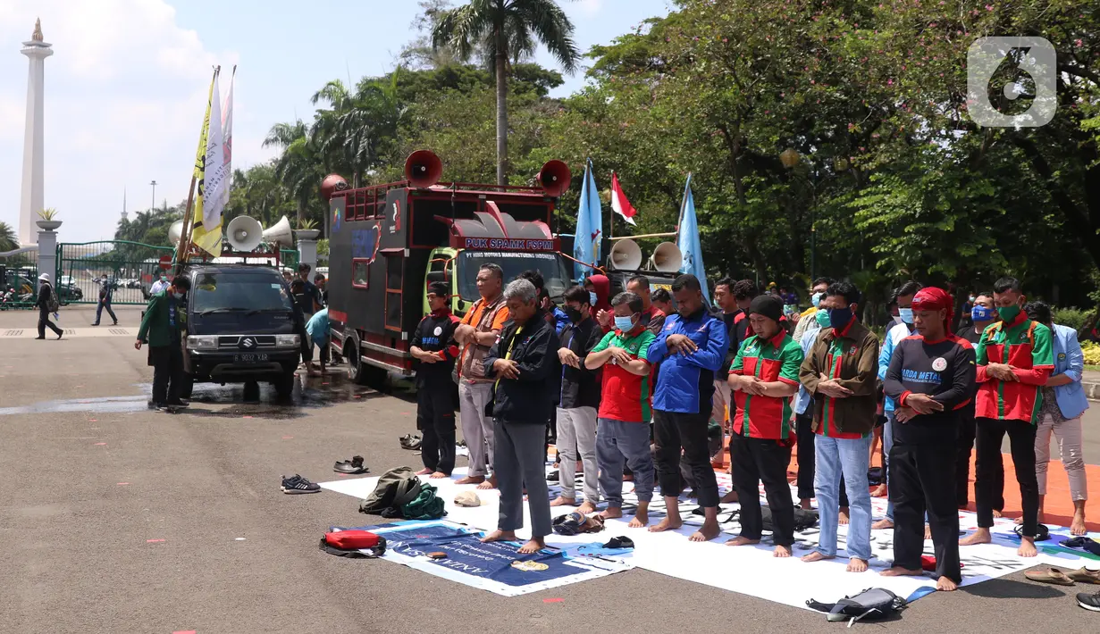 Sejumlah buruh menunaikan salat zuhur di sela aksi Hari Buruh Internasional atau May Day di Jakarta, Sabtu (1/5/2021). Sejumlah massa yang tergabung dalam serikat pekerja menggelar unjuk rasa di Hari Buruh ini. (Liputan6.com/Angga Yuniar)