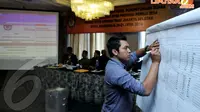 Seorang petugas mencatat hasil penghitungan suara Pileg tingkat kabupaten/kota di Hotel Maharadja, Senin (21/4/14). (Liputan6.com/Johan Tallo)