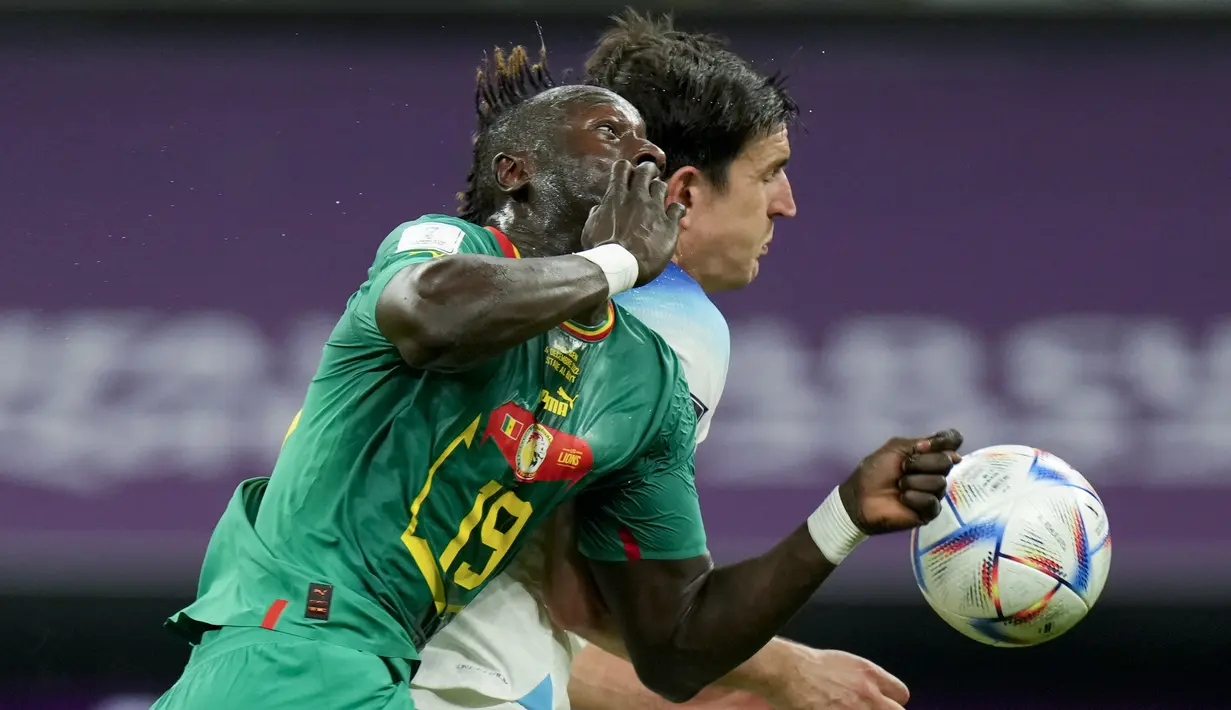 Bek Inggris Harry Maguire dan penyerang Senegal Famara Diedhiou melakukan sundulan pada laga babak 16 besar Piala Dunia 2022 di Al Bayt Stadium, Senin (5/12/2022) dini hari WIB. Dengan hasil ini, Inggris pun dipastikan berhak lolos ke perempat final Piala Dunia 2022 untuk menantang Prancis, sang juara bertahan. (AP Photo/Francisco Seco)