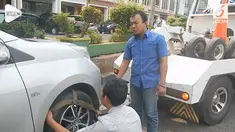 Seorang pria tidak menyadari kendaraannya diderek Dishub karena tidur terlelap.