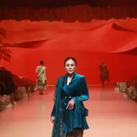 Dipadukan dengan kain batik dan selendang brukat biru. Wulan Guritno juga kenakan sandal gladiator yang terlihat berkelas.