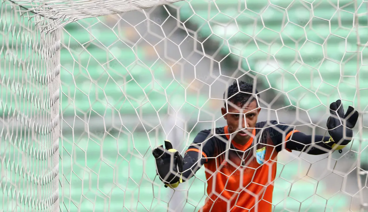 Kiper Persela Lamongan bersantai sejenak sebelum melanjutkan latihan di Stadion Utama Gelora Bung Karno, Jakarta, Kamis (12/5/2016). (Bola.com/Nicklas Hanoatubun)