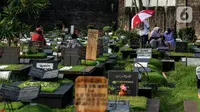 Sejumlah warga berziarah di makam keluarganya di Tempat Pemakaman Umum (TPU) Tanah Kusir, Jakarta, Selasa (29/3/2022). TPU setempat semakin banyak dikunjungi warga yang melakukan tradisi ziarah kubur menjelang Ramadhan. (Liputan6.com/Johan Tallo)