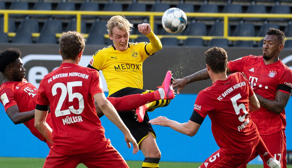 Striker Borussia Dortmund, Julian Brandt, bebrebut bola dengan pemain Bayern Munchen pada laga pekan ke-28 Bundesliga di Stadion Signal Iduna Park, Selasa (26/5/2020) waktu setempat. Bayern Munchen menang 1-0 atas Borussia Dortmund. (AFP/Federico Gambarini/Pool)