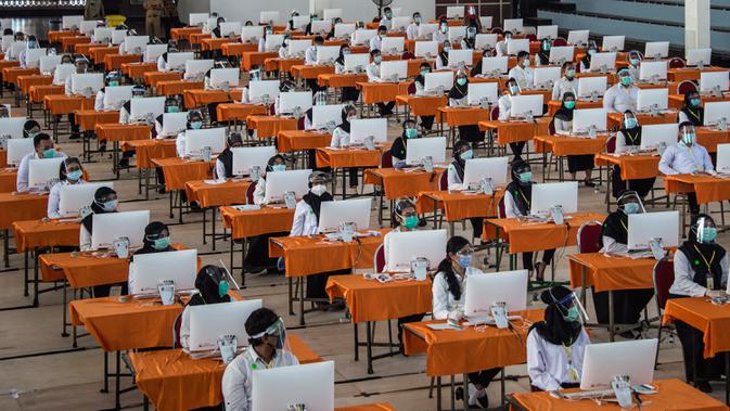 Peserta mengikuti ujian Seleksi Kompetensi Bidang (SKB) di Surabaya, Selasa (22/9/2020). Badan Kepegawaian Daerah (BKD) Kota Surabaya menggelar ujian SKB yang diikuti 1.142 peserta CPNS dengan menerapkan protokol kesehatan pencegahan COVID-19 secara ketat. (Juni Kriswanto/AFP)