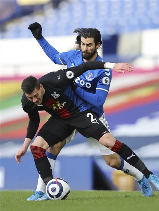 Gelandang Everton, Andre Gomes  dan bek Crystal Palace, Joel Ward  bersaing memperebutkan bola pada pekan ke-30 Liga Inggris di Goodison Park, Selasa (6/4) dini hari WIB. Duel Everton vs Crystal Palace harus berakhir imbang dengan skor 1-1. (Clive Brunskill / Pool via AP)