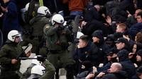 Polisi anti huru-hara Yunani bentrok dengan suporter Ajax Amsterdam sebelum pertandingan Liga Champions melawan AEK Athena di Stadion Olimpiade Athena, Selasa (27/11). Akibat bentrokan ini, sejumlah pendukung Ajax terluka. (AP/Thanassis Stavrakis)