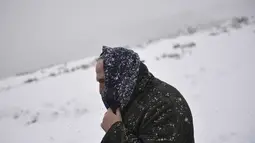 Seorang pria berjalan melalui lanskap bersalju di dekat perbatasan Prancis di Ibaneta, Spanyol utara, Rabu (8/12/2021). Pihak berwenang telah mengumumkan salju dan hujan lebat selama beberapa hari ke depan di utara negara itu. (AP Photo/Alvaro Barrientos)